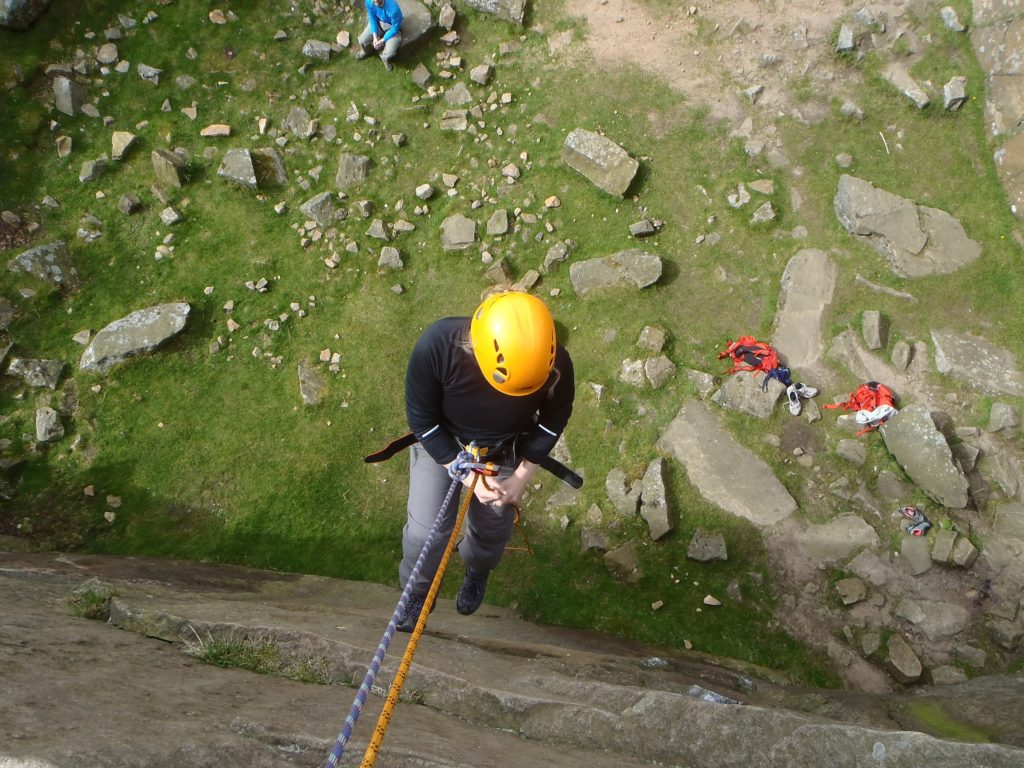 A person abseiling down a steep quarry